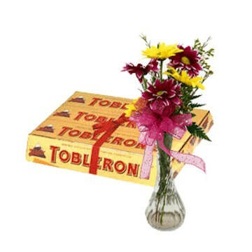 Alpine Treat - $45. A bundle of six Toblerone chocolate and a vase containing bright seasonal flowers.